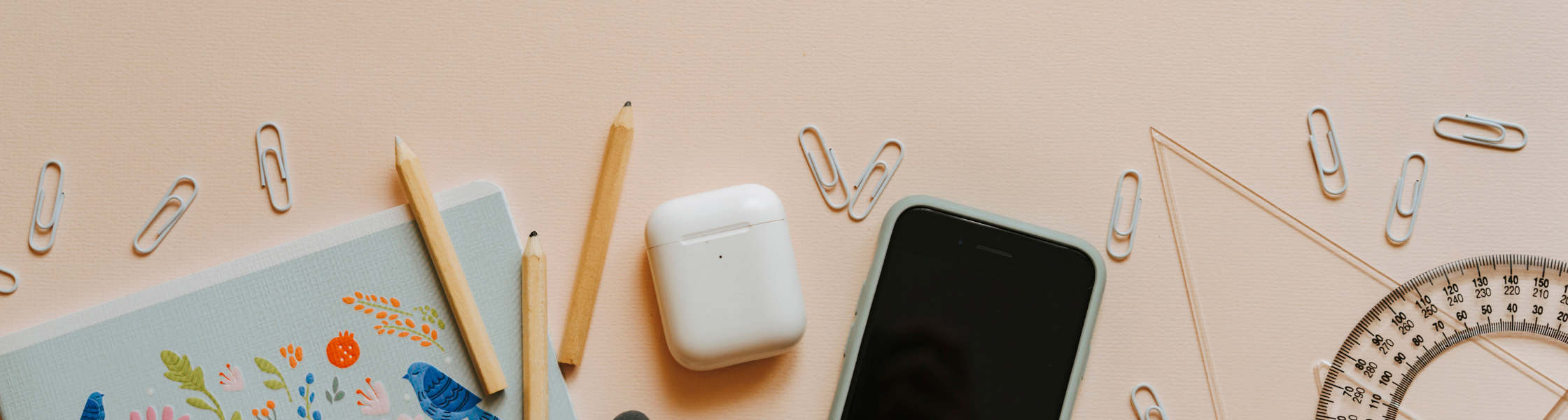 notebook, pencil, and phone on desk