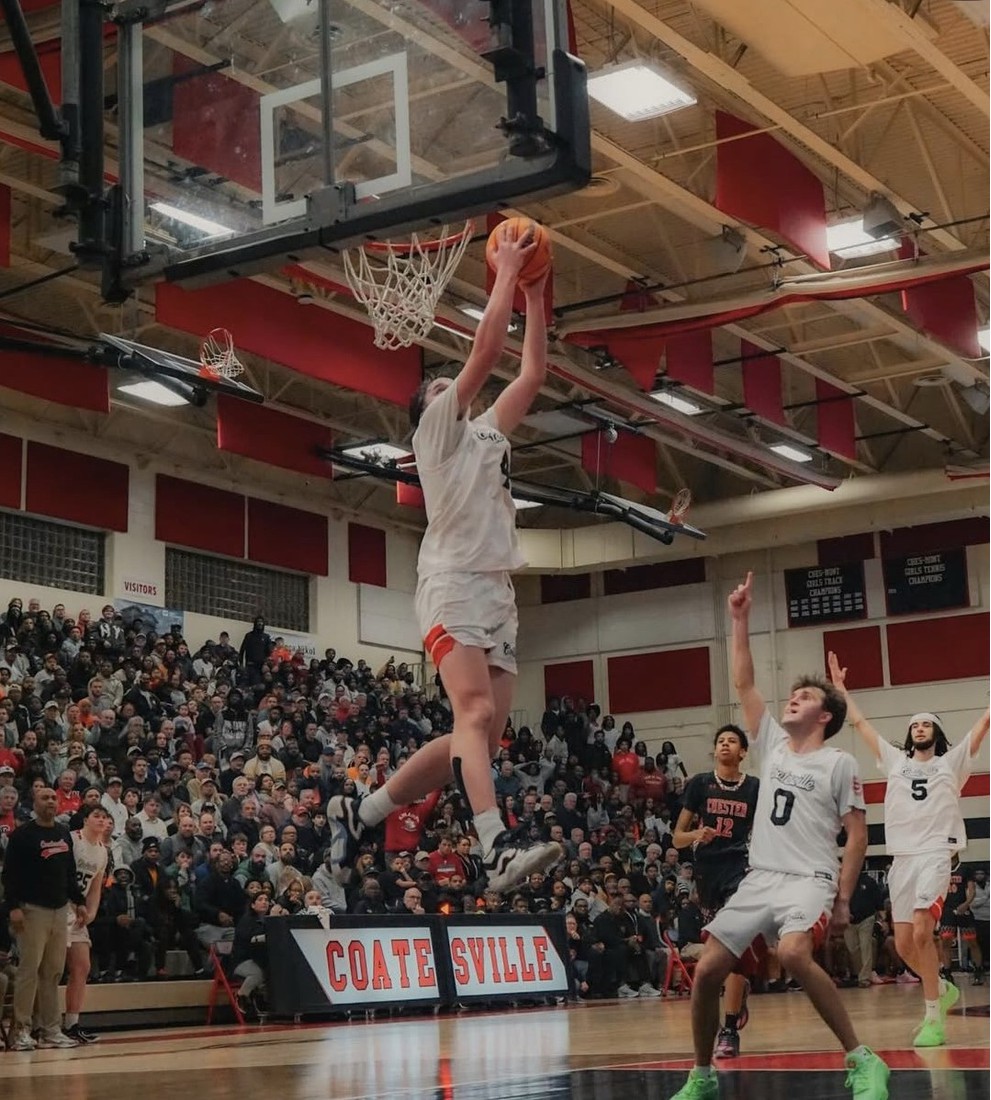 teenage boy jump shot in basketball game in gymnasium