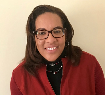 A woman wearing glasses and a red jacket.