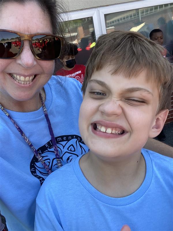 A woman and a boy smiling at the camera.