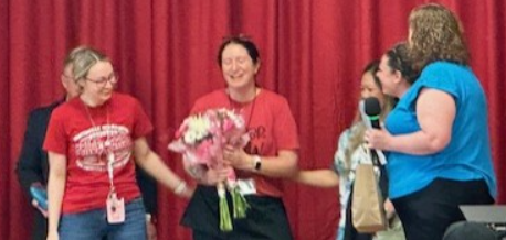 A group of women standing next to each other in front of a red curtain