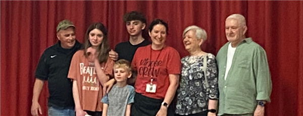 A group of people standing in front of a red curtain