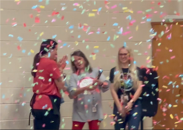 A group of women standing next to each other under confetti