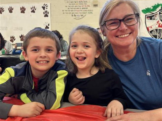 A woman and two children sitting at a table.