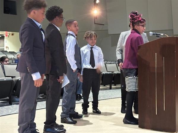 Children standing at podium for school presentation.