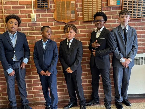 Five boys in suits standing together.