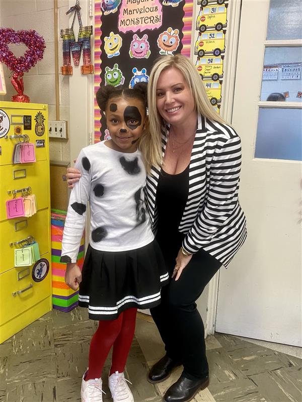 Woman and girl smiling in classroom.