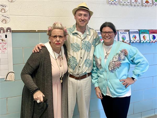 Three people standing in front of a classroom.