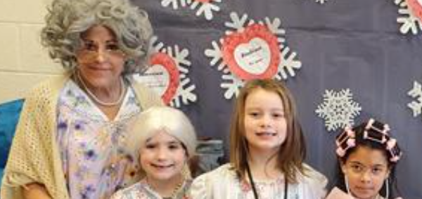 Children and elderly woman smiling for photo.