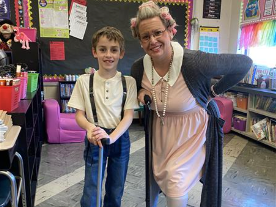 Woman and boy in classroom, woman holding cane.