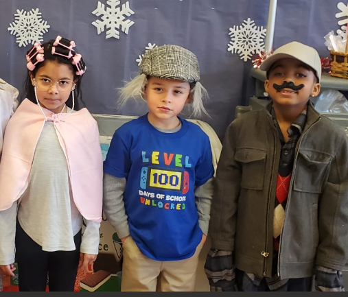 Four kids in costumes smiling for a photo.