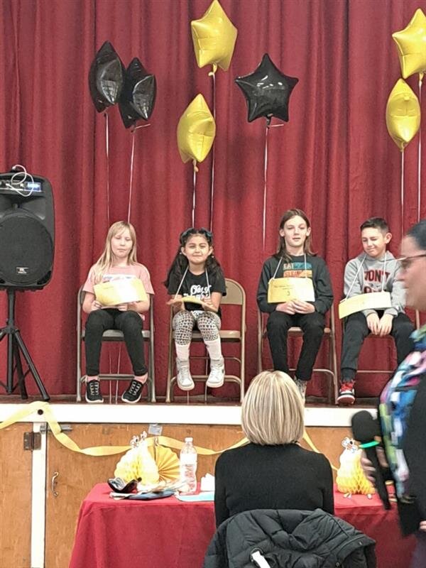 Children sitting at a table with colorful balloons.