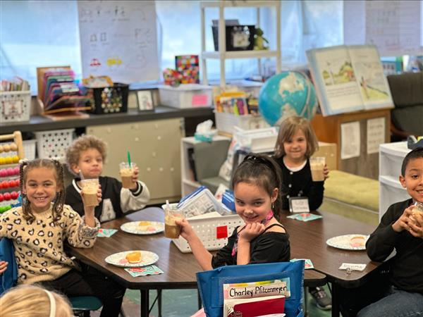 Children sitting at a table eating food.