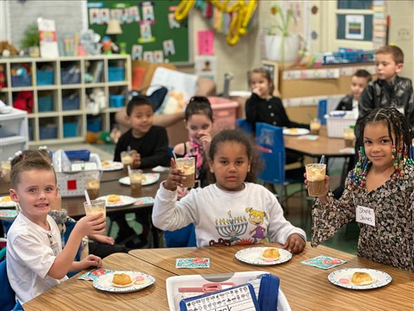 Children sitting at a table eating food.