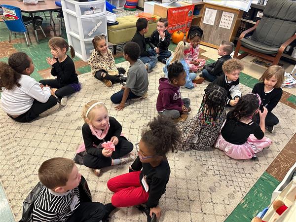 Children sitting at a table eating food.