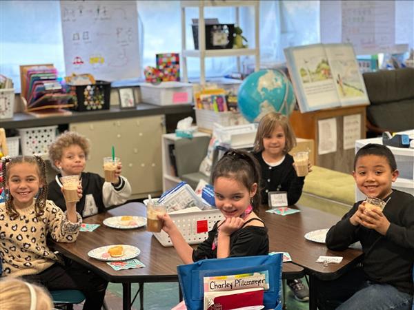 Children sitting at a table eating food.