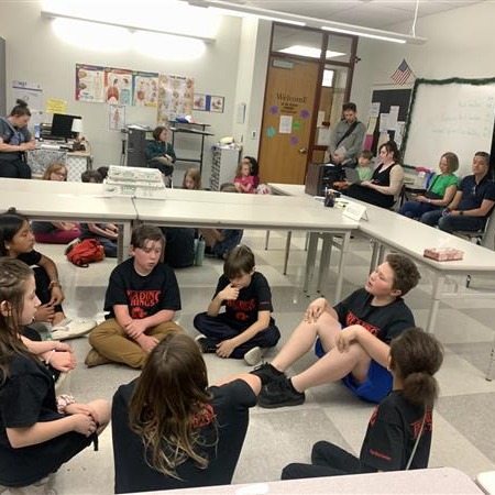 Students sitting around a table in a classroom.