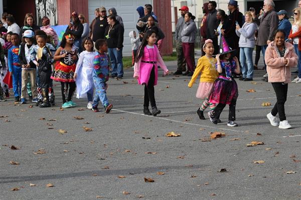 Children in costumes parade down the street during Halloween.