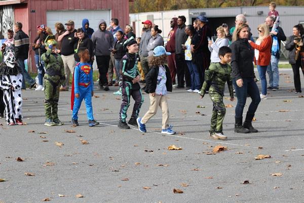 Children in costumes parade down the street during Halloween.