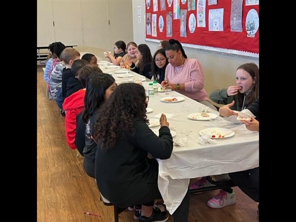 Children enjoying a meal at a spacious table in a bright room.