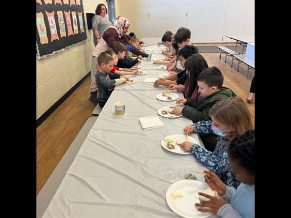 Children enjoying a meal at a spacious table in a bright room.