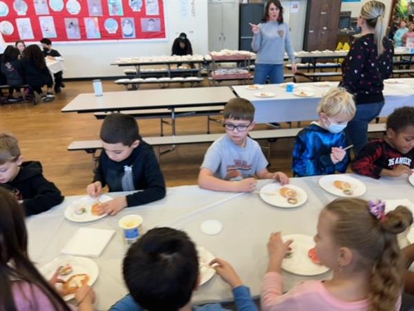 Children enjoying a meal at a spacious table in a bright room.