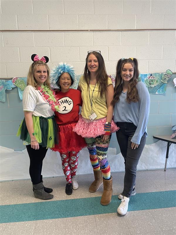 Four women in vibrant costumes smiling for a photo.