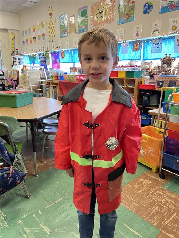  A young boy in a red fireman's coat.