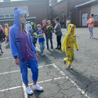 A woman and child in matching costumes walk together.