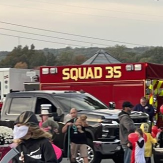 A group of people standing in front of a fire truck.