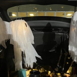 A car with Halloween decorations both inside and outside.