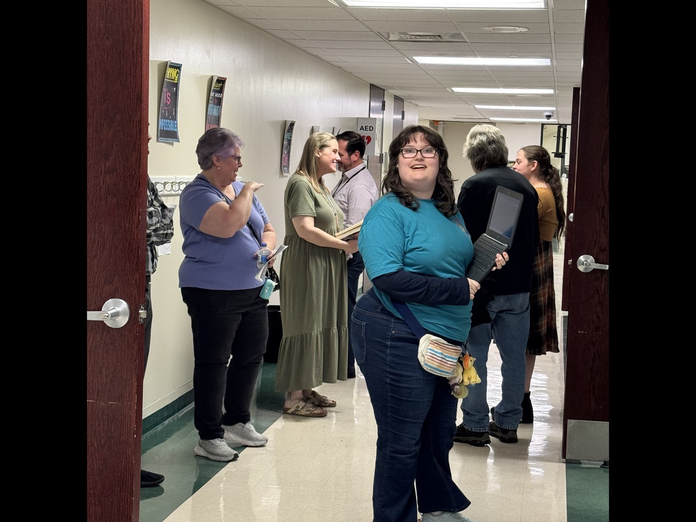 students, parents and teacher chat in hallway