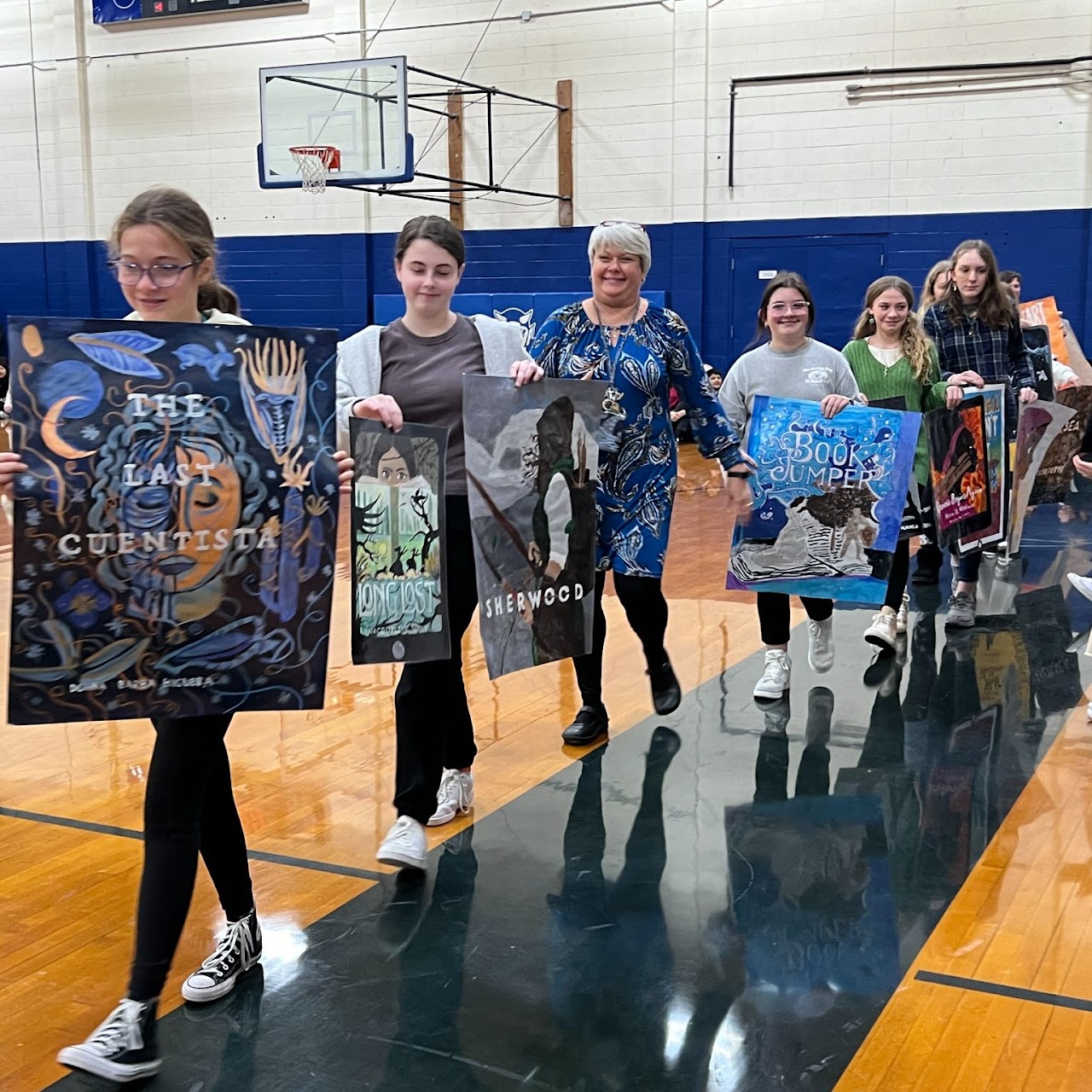 kids walking in gym with book posters 