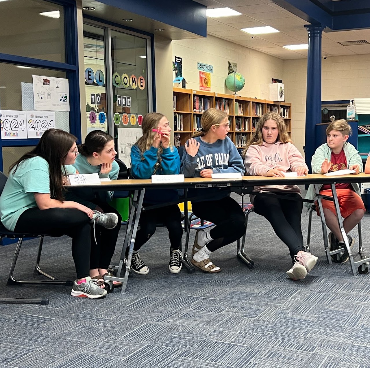 kids sitting at table reading together 