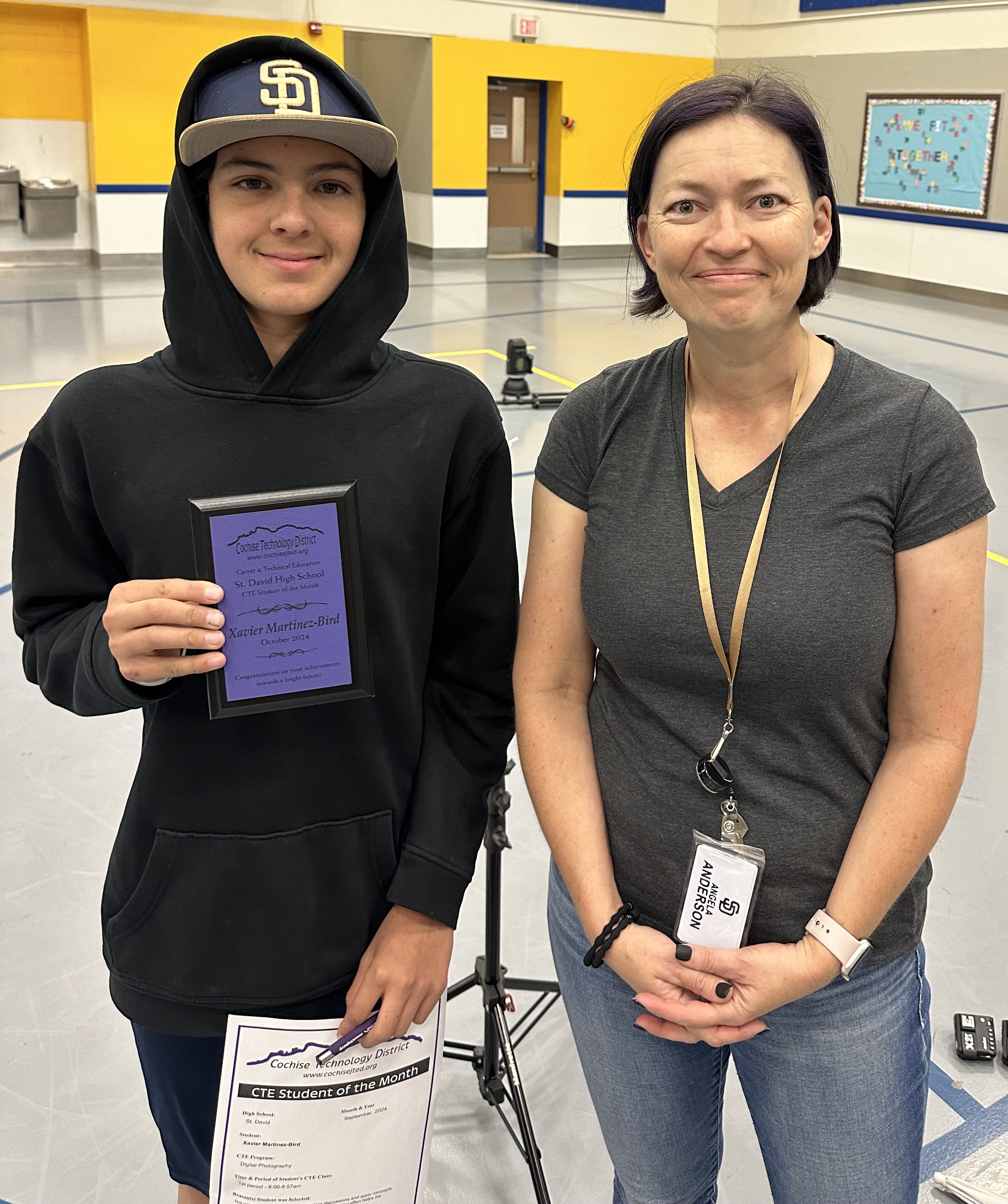 student holding award and teacher