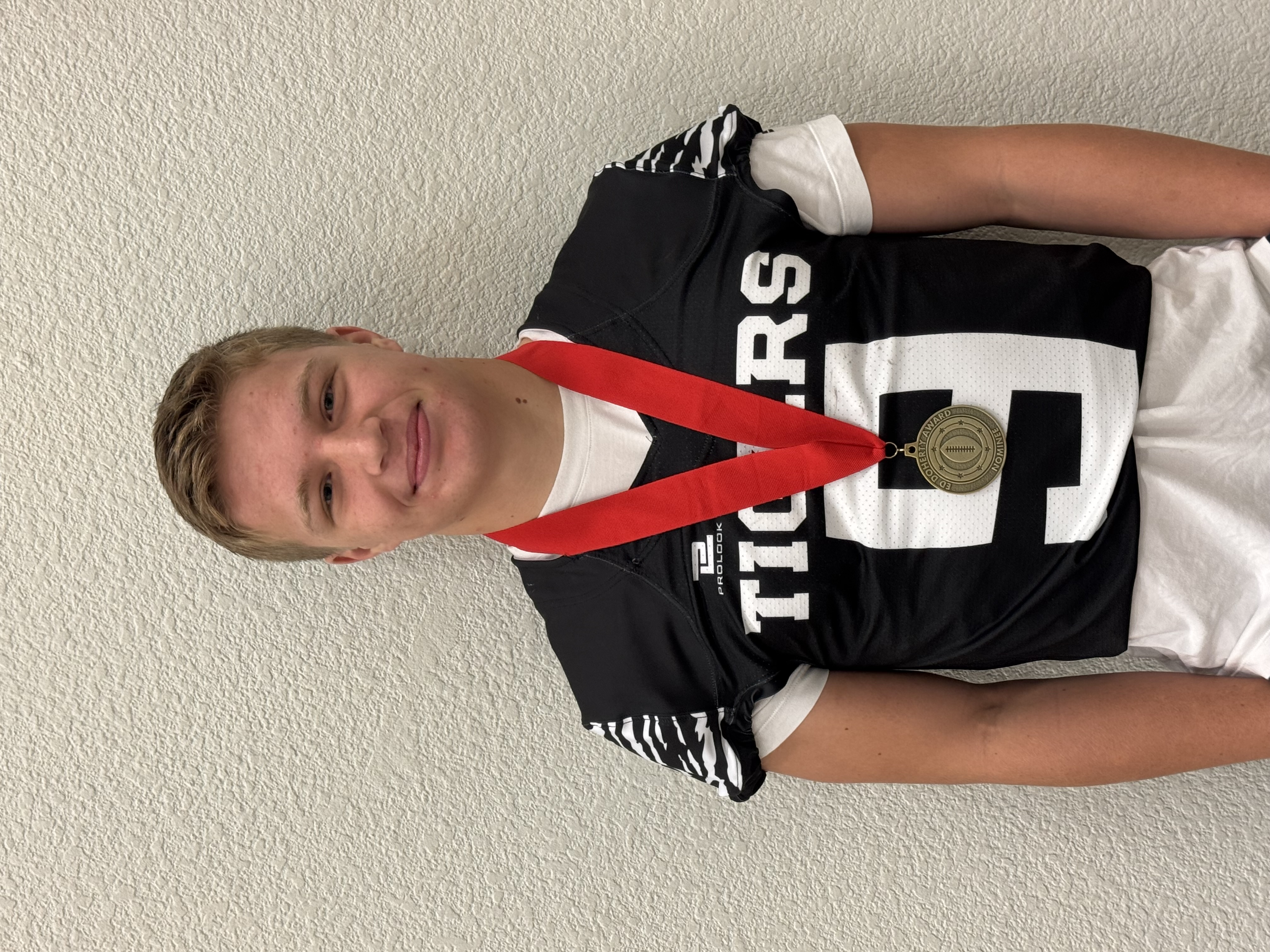 Athlete wearing football uniform and a medal