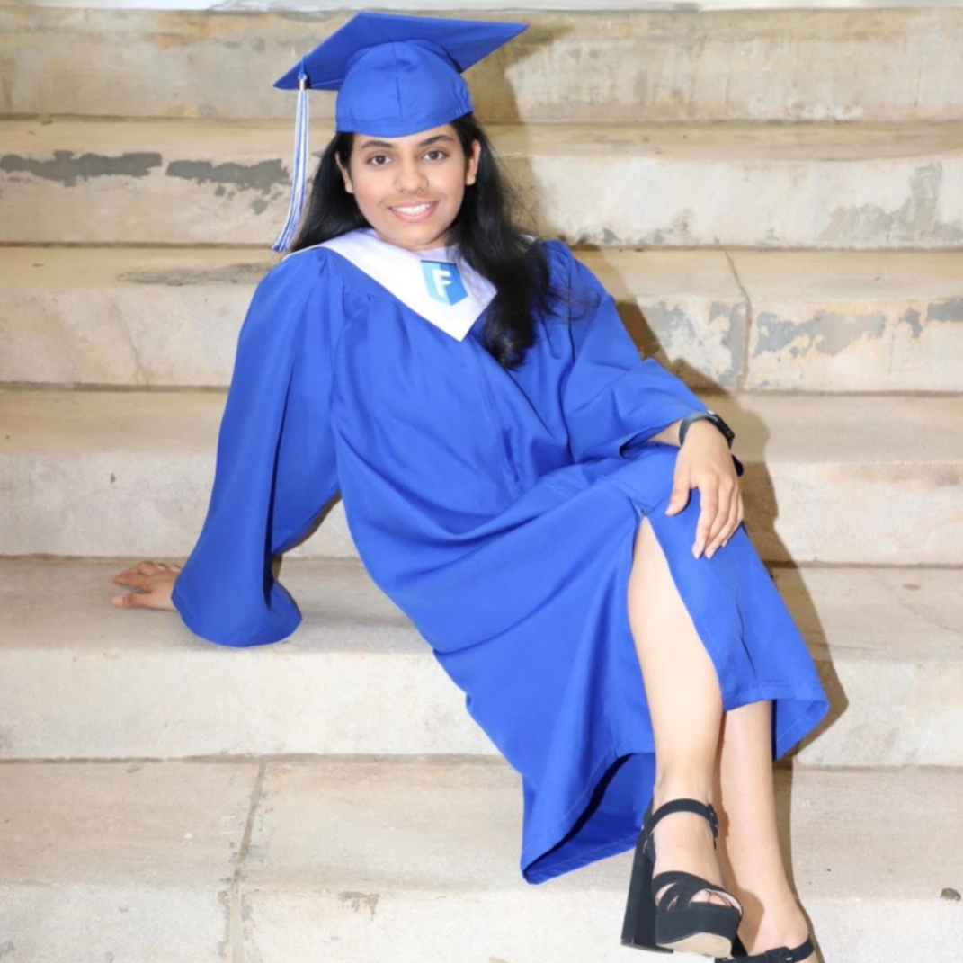 Student on steps in cap and gown