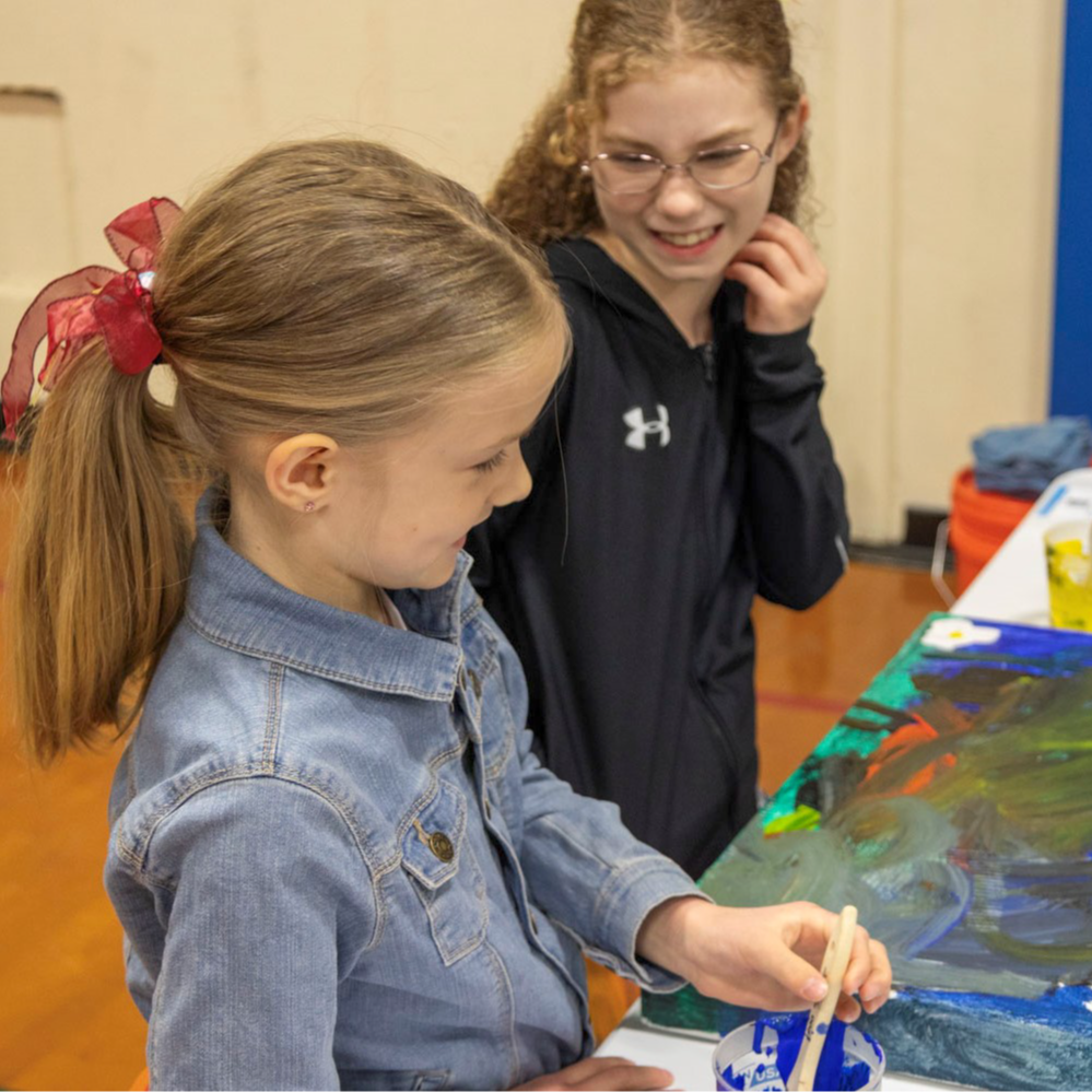 Two children paint a mural