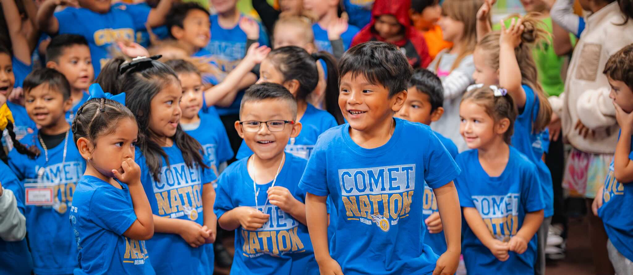 students cheering at their homecoming pep rally assembly 