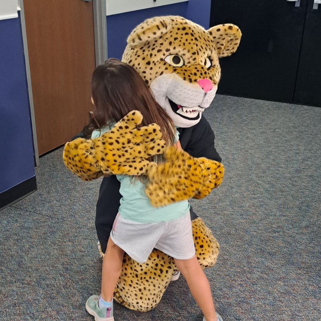 girl hugging mascot