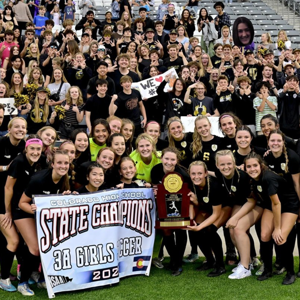 girls soccer team with champion banner