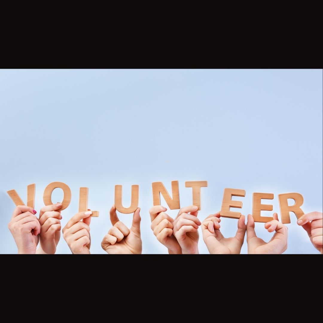 fingers holding letters "volunteer"