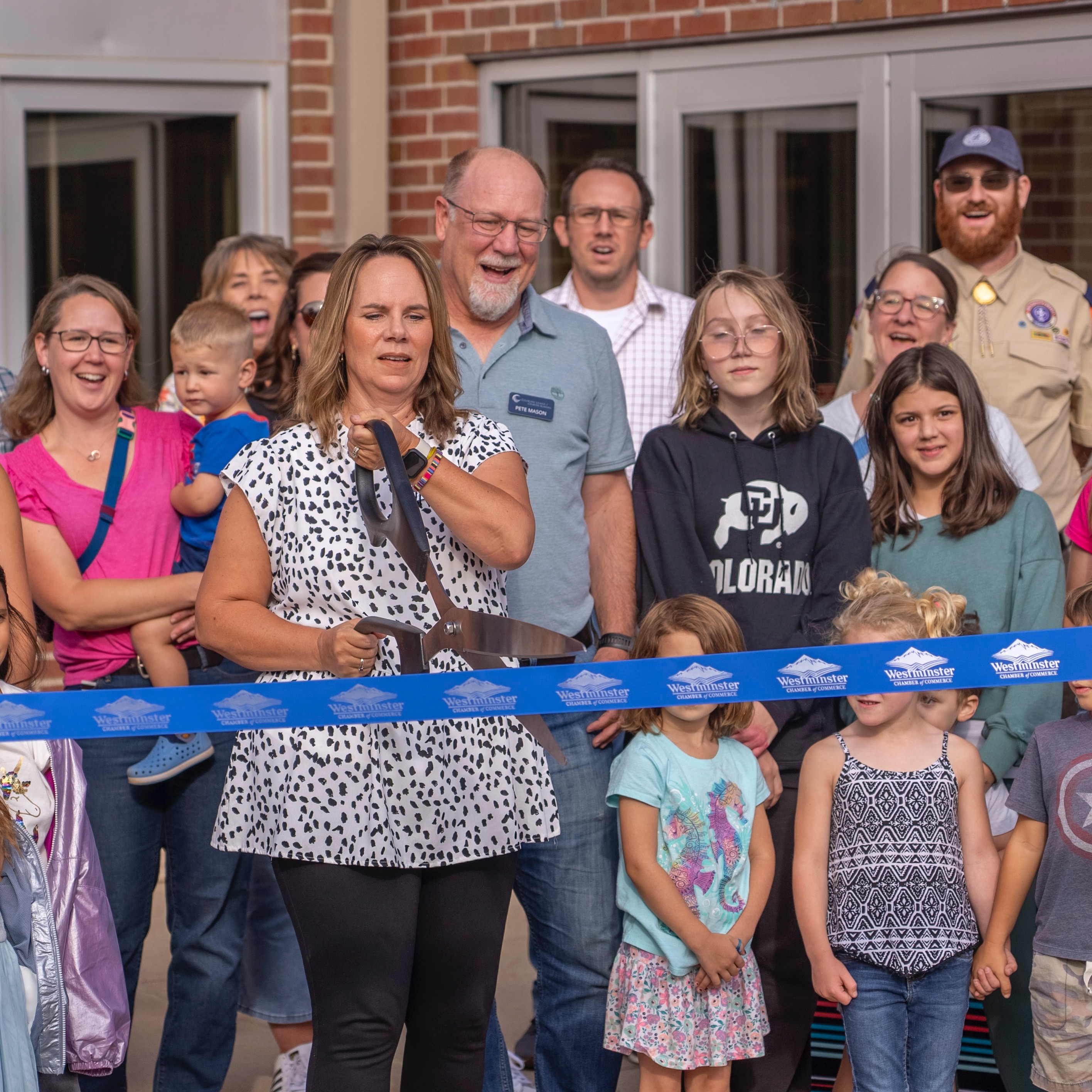 Principal cutting ribbon with community behind