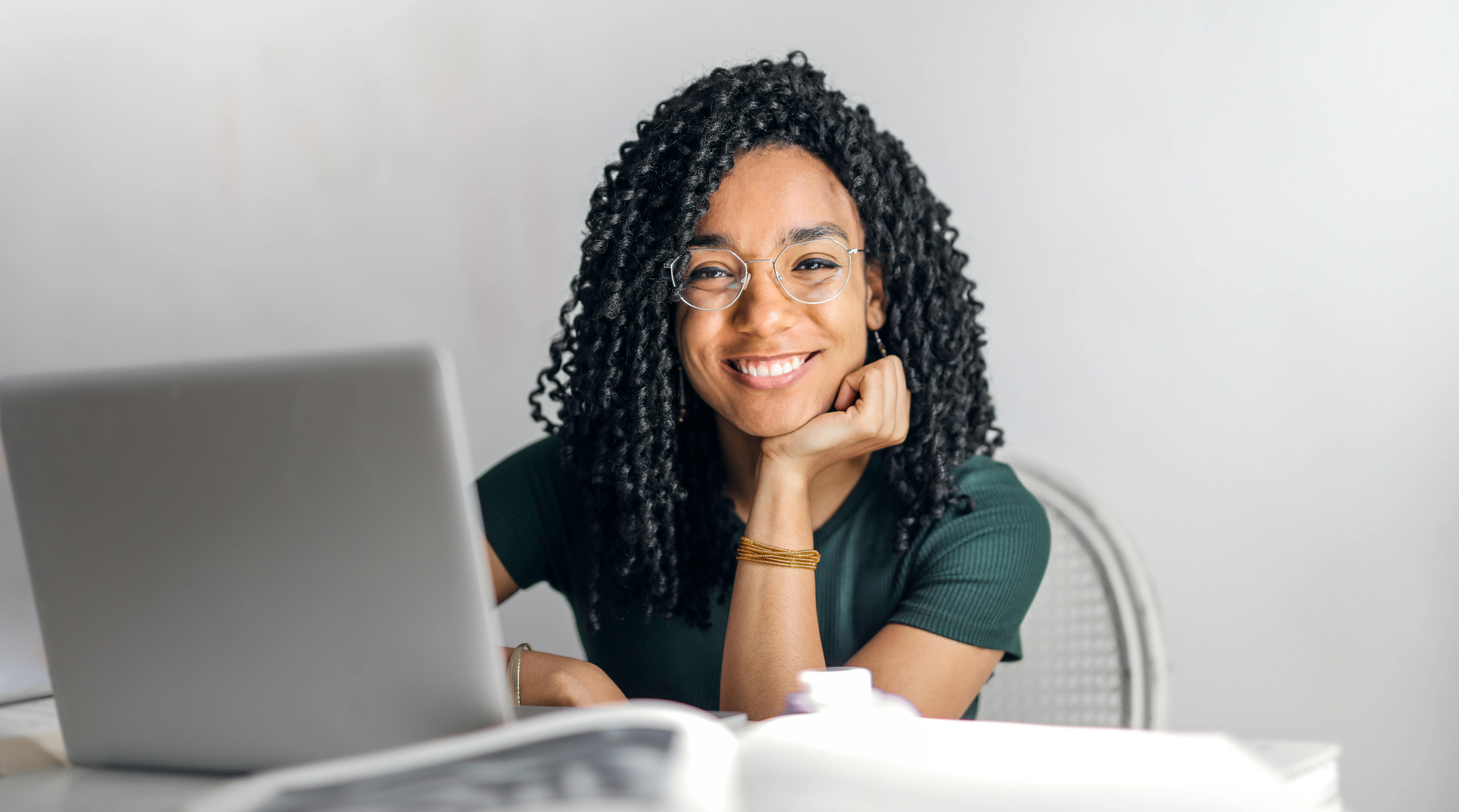 woman smiling behind laptop computer