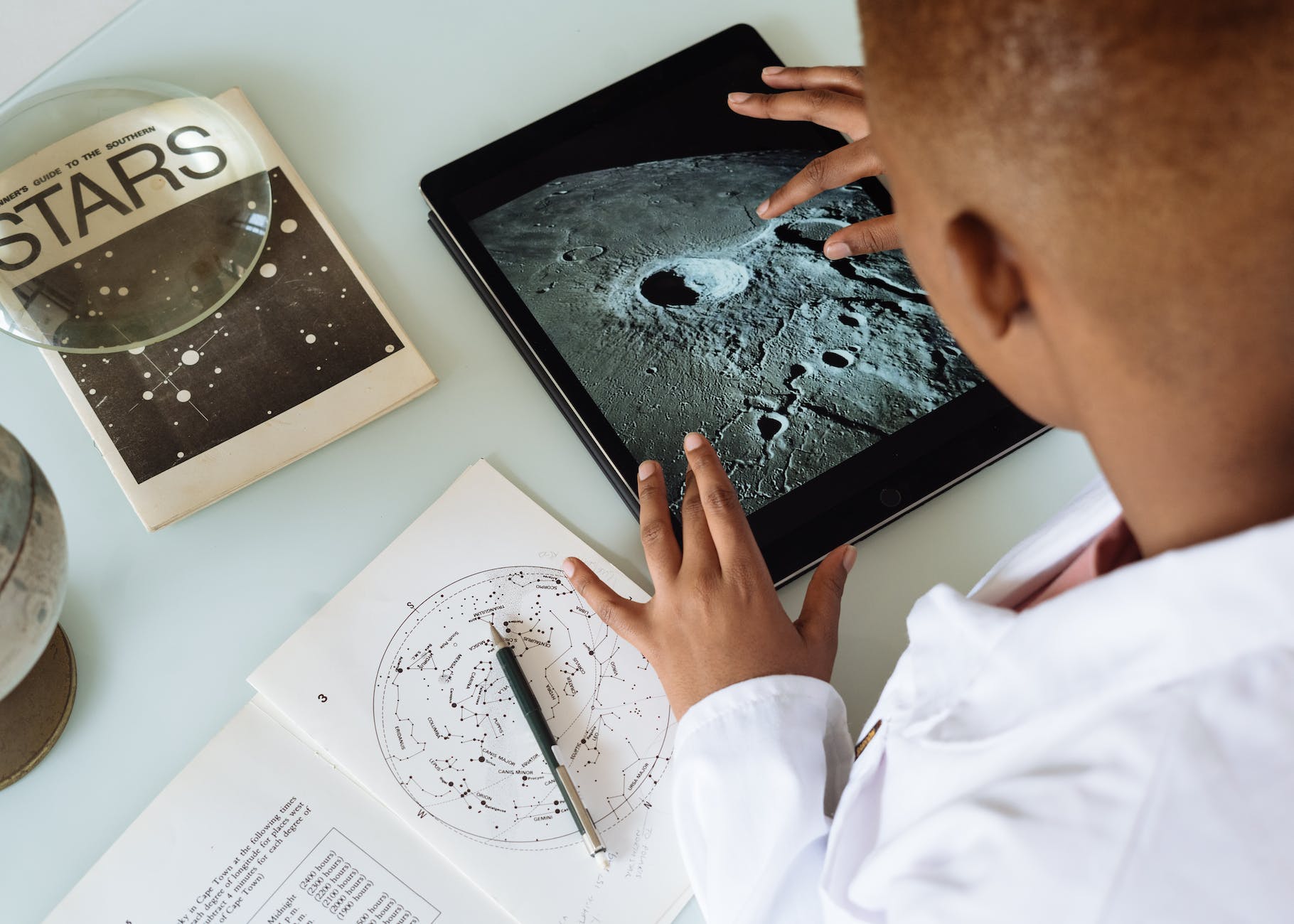 student studying craters of moon on tablet at observatory