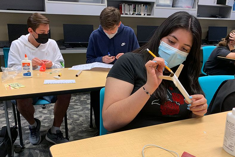 three students working on projects