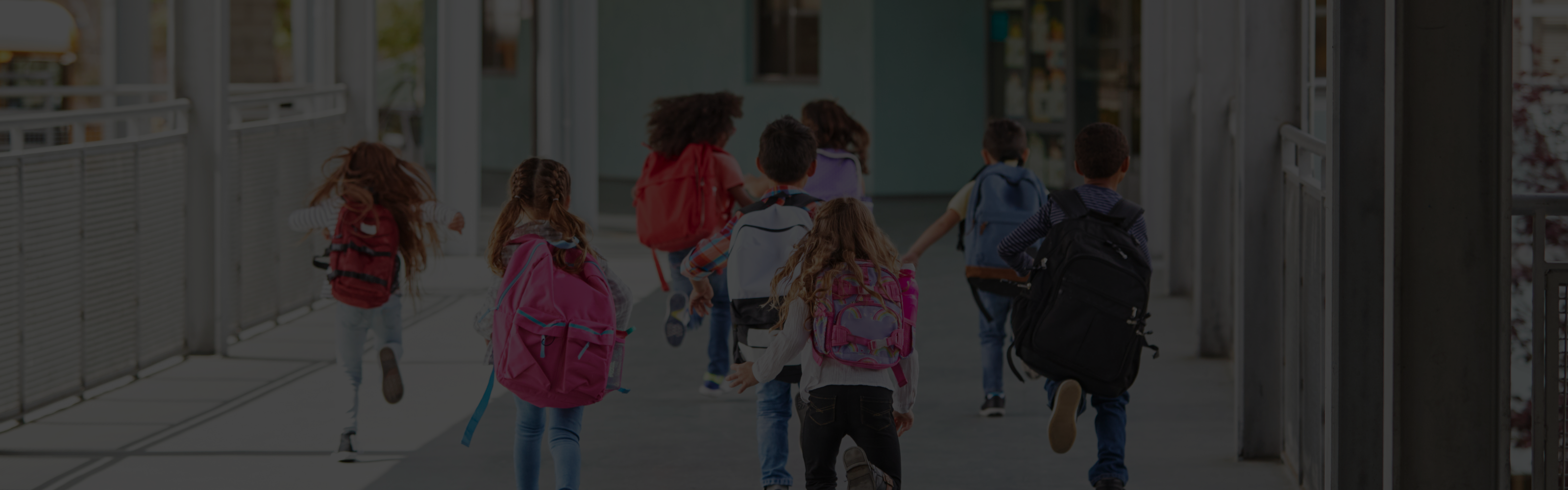 Students with backpacks running toward a classroom