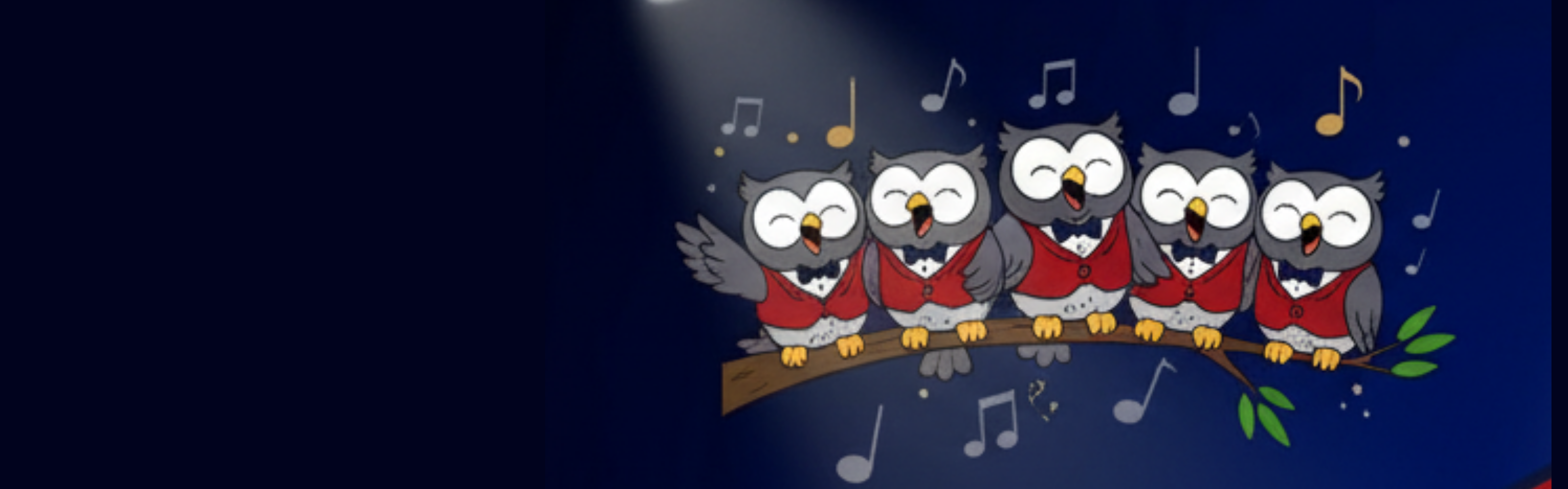 A group of eight cartoon owls, colored in school-themed red and maroon, are perched on a tree branch singing. They are on a stage illuminated by spotlights from above, with musical notes floating around their heads.