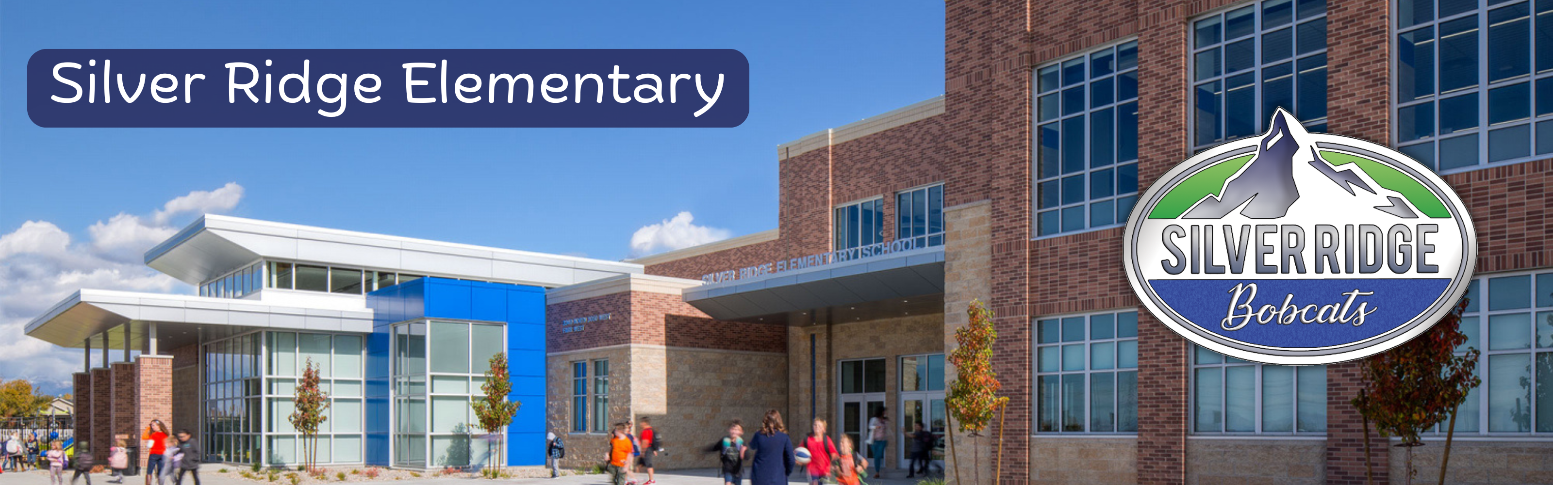 This is a panoramic photograph of Silver Ridge Elementary School on a bright, sunny day. The modern school building features a combination of red brick, light stone accents, and a distinctive blue entrance vestibule with extensive glass panels.  Key Visual Elements:  Building: A multi-story modern school structure with a large red brick wing, extensive windows, and a prominent blue and glass entrance area. A partial school sign, "SILVER RIDGE ELEMENTARY SCHOOL," is visible above the entrance doors.  Logo and Branding: The top left corner features a dark blue banner with the text "Silver Ridge Elementary" in white font. On the far right, there is a large, polished oval logo featuring a mountain peak graphic with a green stripe, and text below that reads "SILVER RIDGE Bobcats" in stylized fonts.  Students: A group of elementary-aged students, wearing backpacks and varied clothing, are actively moving around the foreground courtyard, some walking near the entrance, others playing.  Landscape: The foreground has paved walkways, young decorative trees in fall foliage, and some landscaping bushes.  Background: A clear blue sky filled with scattered white cumulus clouds. In the far distance, faint snow-capped mountains can be seen.  The image is a professional exterior shot designed to represent the school.