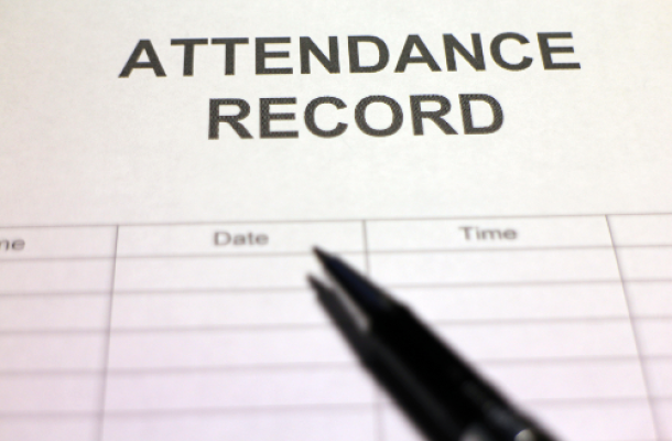 Attendance record being signed on a desk.